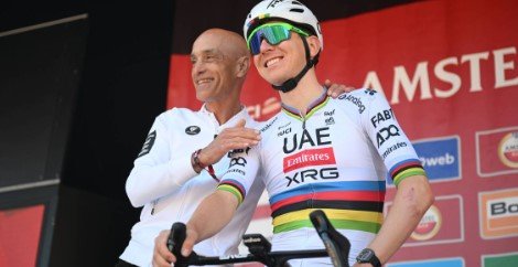 UAE Team Emirates CEO Mauro Gianetti speaking near team vehicles during a major road cycling race