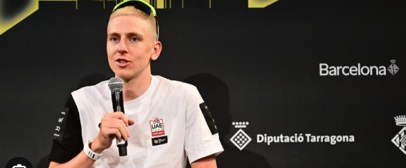 Tadej Pogačar wearing UAE Team Emirates jersey speaking into press microphones about anti-doping testing.